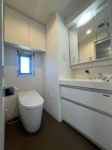 a white bathroom with a toilet and a sink at REGNO COMFORT ASAKUSA Ⅳ in Tokyo