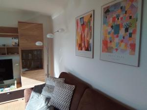 a living room with a couch and paintings on the wall at Ferienwohnung Josi in Heidenheim an der Brenz