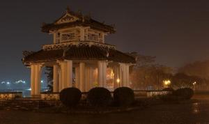 a large building with a tower at night at Lam Bao Long Hotel in Hue