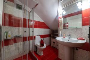 a red and white bathroom with a sink and a toilet at Joan's apartment in Iliopoulaíika
