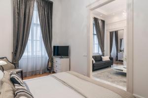 Schlafzimmer mit einem Bett und einem Spiegel in der Unterkunft Basilica Palace in Budapest