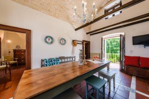 jadalnia z dużym drewnianym stołem i krzesłami w obiekcie HelloApulia Masseria Don Sisto - 10 guests w Alberobello