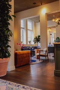 Hotel Ryder I Den Bosch - Vught في سيرتوخيمبوس: غرفة معيشة مع أريكة وطاولة