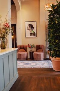 a waiting room with two chairs and a plant at Hotel Ryder I Den Bosch - Vught in Den Bosch
