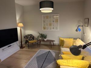 uma sala de estar com um sofá e uma televisão de ecrã plano em Fig Tree House, family friendly, 1 min Sea em Kent
