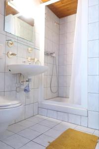 uma casa de banho com um lavatório, um chuveiro e um WC. em City Garni em Martigny-Ville