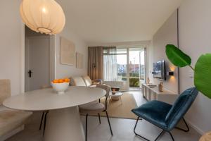 a living room with a white table and chairs at Appartement - Nieuwstraat 1 - Zoutelande 'Kurhaus - 2' in Zoutelande