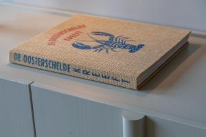 a book sitting on top of a table at Welcome in - Appartementen Kurhaus - Nieuwstraat 1 Zoutelande, nabij strand, terras, sauna in Zoutelande