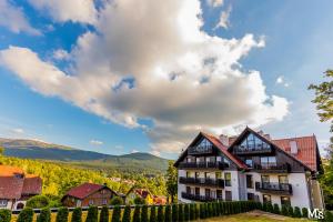 una casa in un villaggio con montagne sullo sfondo di Panorama Gór a Szklarska Poręba