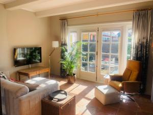 a living room with a couch and a tv at Topzomer in Sleat in Sloten
