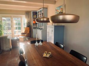 a dining room with a wooden table and chairs at Topzomer in Sleat in Sloten