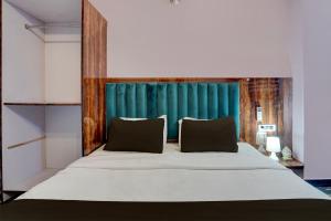 a bedroom with a large bed with a blue headboard at OYO Flagship Swastik Inn in Lucknow