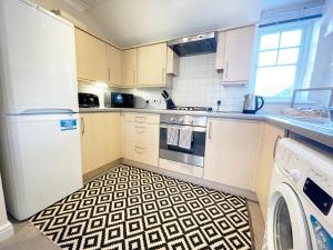 uma cozinha com piso preto e branco em Travaal.©om - 2 Bedroom Apartment - Farnborough em Farnborough