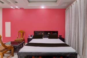 - une chambre avec un lit et un mur rouge dans l'établissement OYO Flagship Hotel Blue Lake Inn, à Lucknow