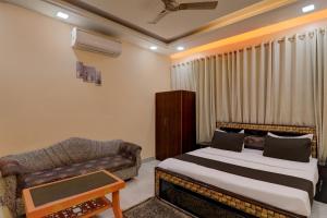 - une chambre avec un lit et un canapé dans l'établissement OYO Flagship Hotel Blue Lake Inn, à Lucknow