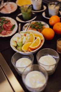 a table with plates of food and bowls of fruit at Hotel Ryder I Den Bosch - Vught in Den Bosch