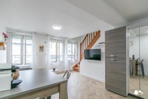 ein Wohnzimmer mit einem Tisch und einem TV in der Unterkunft MBA Splendide Appart - Le Raincy RER Banlieue Paris in Le Raincy