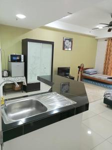 a kitchen with a stainless steel sink in a room at Caliph Suite Apartment Homestay D'Perdana Sri Cemerlang Condominium Kota Bharu in Kota Bharu