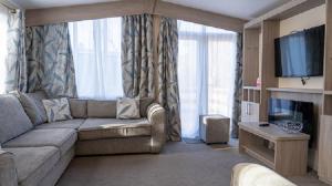uma sala de estar com um sofá e uma televisão de ecrã plano em Newby Bridge Country Caravan Park em Newby Bridge