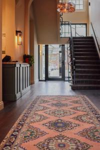 a lobby with a rug on the floor and a staircase at Hotel Ryder I Den Bosch - Vught in Den Bosch