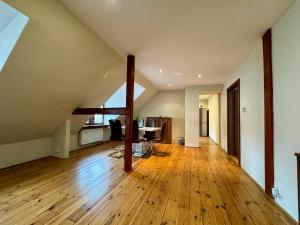 an attic room with a wooden floor and a table at Apartmány Laubeho náměstí in Teplice