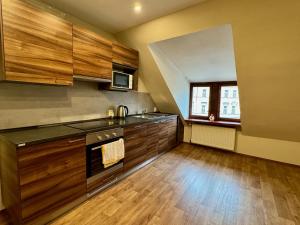 a large kitchen with wooden cabinets and a window at Apartmány Laubeho náměstí in Teplice