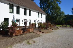 a white building with potted plants in front of it at Ferienhof Verse Ferienwohnung Kornkammer in Lennestadt