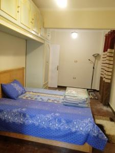 een slaapkamer met een bed met een blauw dekbed bij شقق مفروشة وغير مفروشة in Caïro