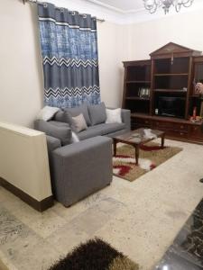 een woonkamer met een bank en een tafel bij شقق مفروشة وغير مفروشة in Caïro