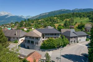 an aerial view of a home in a town with mountains at Auberge Le Semnoz in Saint-Jorioz