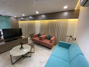 a living room with a couch and a tv at Lords Eco Inn Navsari in Navsāri