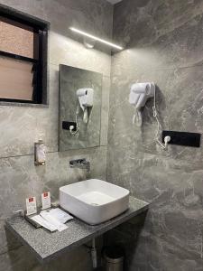 La salle de bains est pourvue d'un lavabo et d'un miroir. dans l'établissement Lords Eco Inn Navsari, à Navsāri