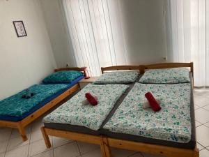 2 camas en una habitación con almohadas rojas. en ubytování u Hradu, en Nové Hrady