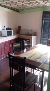 eine Küche mit einem Holztisch mit Stühlen und einer Tableasteryasteryasteryastery in der Unterkunft Kuchi Villa in Kalutara