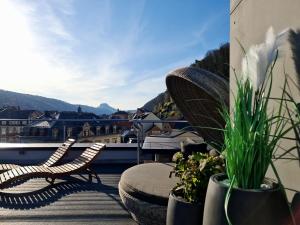 einen Balkon mit zwei Stühlen und Pflanzen auf dem Dach in der Unterkunft Hotel Lindenhof Bad Schandau in Bad Schandau