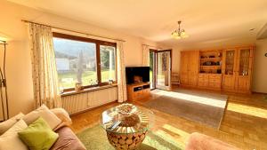 sala de estar con sofá y mesa de cristal en Ferienhaus Balsbergblick en Unterwössen