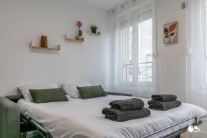 ein weißes Zimmer mit einem Bett und Handtüchern darauf in der Unterkunft MBA Splendide Appart - Le Raincy RER Banlieue Paris in Le Raincy
