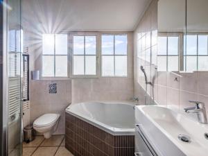 a bathroom with a tub and a toilet and a sink at Dutchen Waddenduyn in Den Burg +47 photos