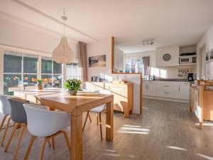 a large kitchen with a wooden table and chairs at Dutchen Waddenduyn in Den Burg