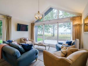 a living room with couches and a large window at 2 Pheasant in East Ilsley