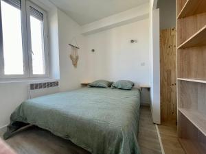 カルカソンヌにあるLes Appartements - Canal du Midiのベッドと窓のある寝室