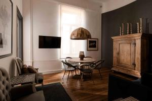 Art Pantheon - Suites & Apartments في أثينا: غرفة معيشة مع طاولة وكراسي ونافذة