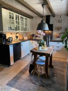 Koselig rom i tømmerhus, inkl morgenkaffe في Eidsvoll: مطبخ مع طاولة مع نبات الفخار عليها