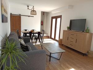 sala de estar con sofá y TV en Casa Rural El Almez, en Horcajo de Santiago