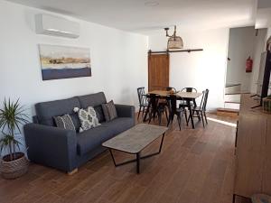 sala de estar con sofá azul y mesa en Casa Rural El Almez, en Horcajo de Santiago