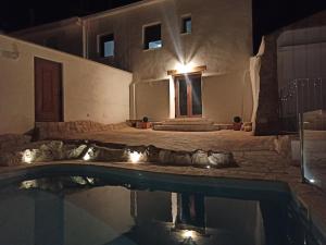 una casa con piscina por la noche en Casa Rural El Almez, en Horcajo de Santiago