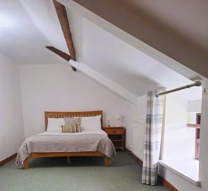 a bedroom with a bed and a ceiling fan at Celtic Minor Cottage in Ystalyfera