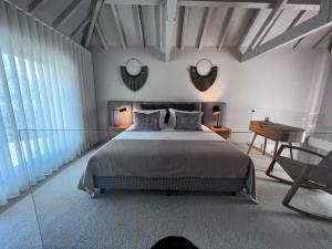 1 dormitorio con 1 cama, escritorio y 2 espejos en Casas Bouça Maria - Aqua Village & Sports en Marco de Canavezes