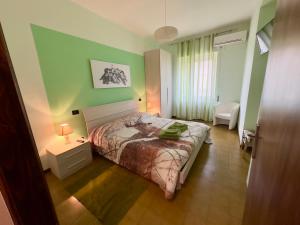 1 dormitorio con 1 cama en una habitación con paredes verdes en L'OLIVO DI EVELINA en Bagnoregio