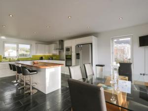 a kitchen with a table and some chairs in it at Merse End in Dalbeattie